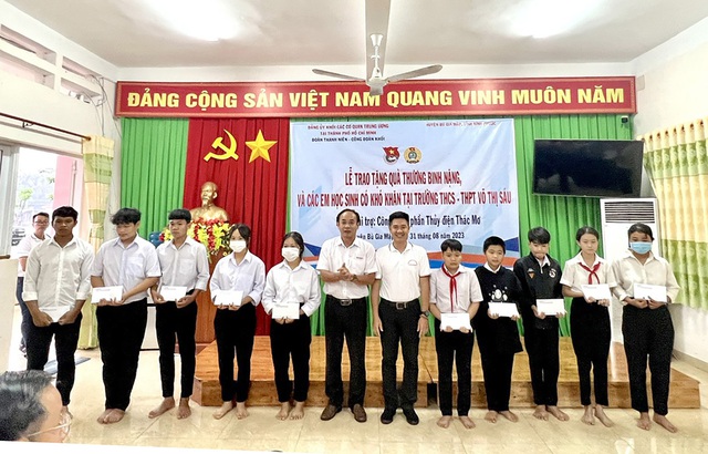 Đại diện Công ty CP Thủy điện Thác Mơ tặng quà cho các em học sinh khó khăn