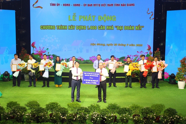 Ông Trần Văn Chính, Chủ tịch Ủy ban MTTQ Việt Nam tỉnh Hậu Giang (bìa phải) tiếp nhận bảng ủng hộ chương trình nhà đại đoàn kết (ảnh: Trường Sơn)