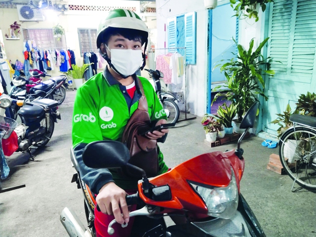 Sau giờ làm việc ở công ty, anh Trọng Hùng tranh thủ chạy xe ôm công nghệ để kiếm thêm thu nhập