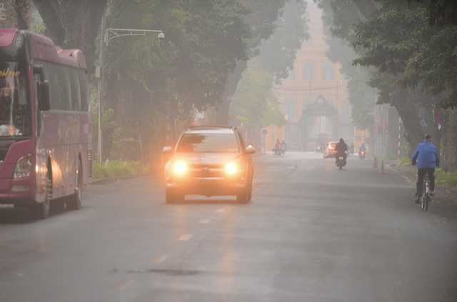 Hà Nội 'chìm' trong sương mù lúc sáng sớm, nhiều phương tiện bật đèn pha đi đường- Ảnh 1.