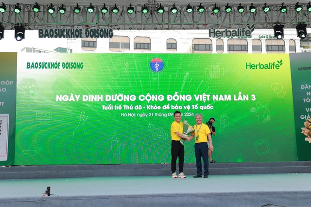 Nhà báo Trần Tuấn Linh, Tổng Biên tập Báo Sức khỏe và Đời sống, Trưởng ban Tổ chức trao hoa cảm ơn đại diện Herbalife Việt Nam