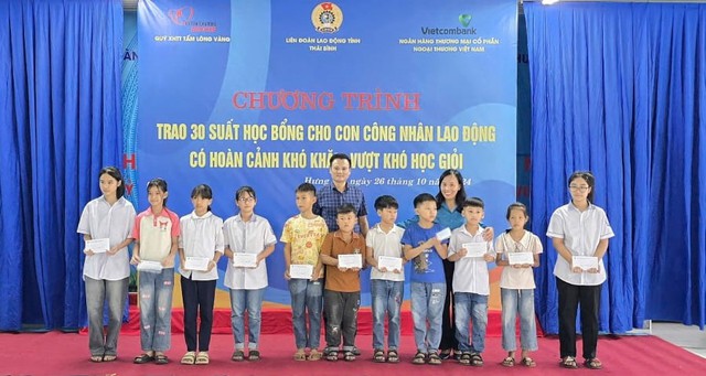 1-Đại diện Vietcombank, ông Đỗ Chiến Thắng - Phó giám đốc Vietcombank Thái Bình (thứ 5 từ trái sang) cùng bà Phạm Thị Thắng - Phó chủ tịch LĐLĐ tỉnh Thái Bình (thứ 3 từ phải sang) trao học bổng tại chương trình