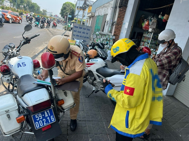 CSGT TP.HCM phạt xe ôm công nghệ, shipper vì dùng điện thoại khi lái xe: Mưu sinh phải đúng luật- Ảnh 1.