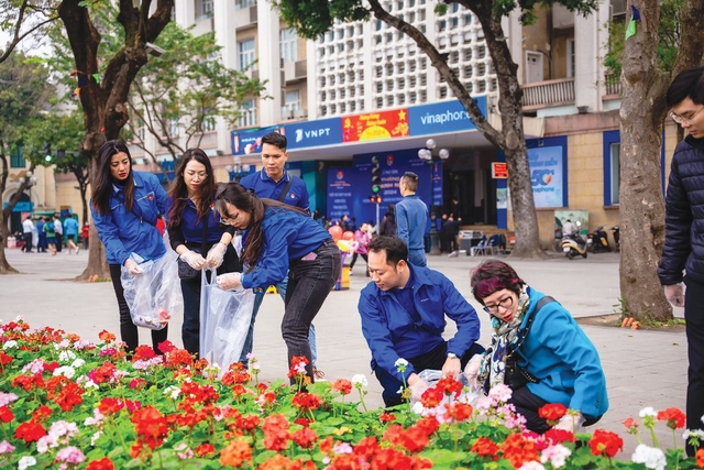 Thanh niên nhặt rác làm sạch đẹp vườn hoa nơi công cộng của Hà Nội