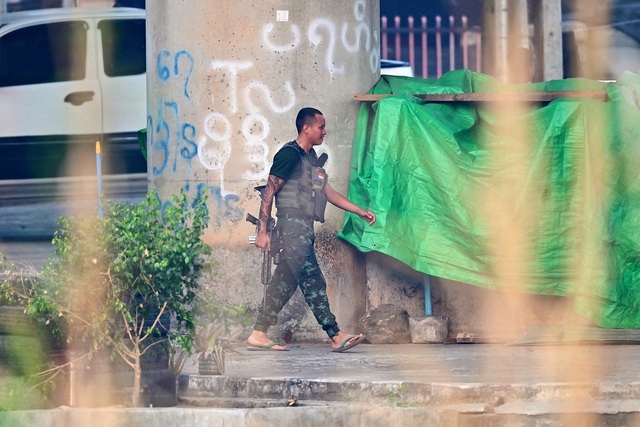 Thành viên của một lực lượng dân quân Myanmar cầm vũ khí khi đi về phía Myanmar, được nhìn thấy từ huyện Mae Sot của Thái Lan vào ngày 11.4