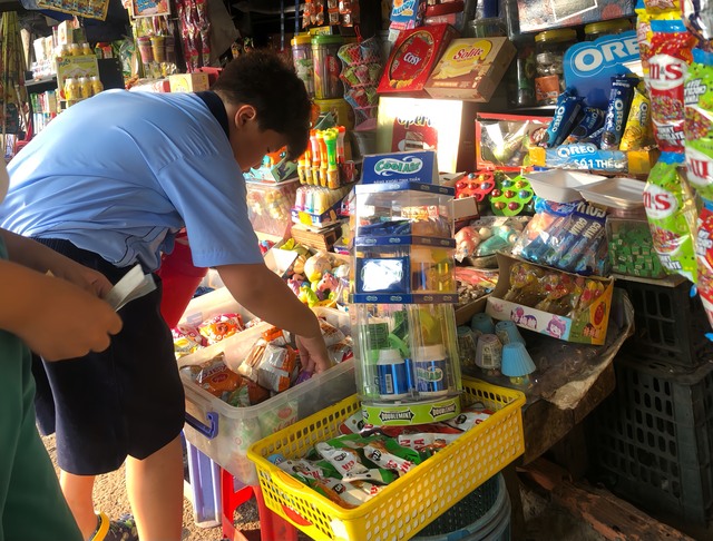 Học sinh mua đồ ăn vặt tại một hàng quán trước cổng 1 trường tiểu học ở Q.Bình Thạnh