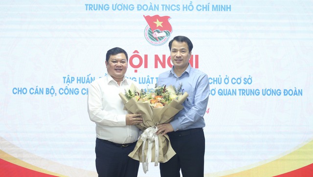 Anh Ngô Văn Cương (bên phải) tặng hoa cảm ơn ông Trần Xuân Hiền, Phó vụ trưởng Vụ Công tác thanh niên (Bộ Nội vụ), đã chia sẻ thông tin tại hội nghị