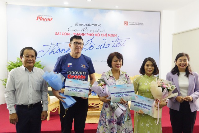 Ông Mai Ngọc Phước - Phó chủ tịch Hội Nhà báo TP.HCM (trái) và Tổng biên tập Báo Phụ Nữ TP.HCM Lý Việt Trung (phải) trao giải cho các tác giả đoạt giải tháng đợt 1