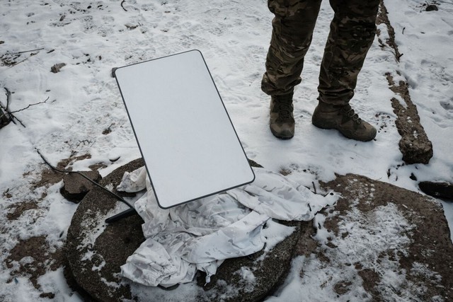 Một binh sĩ Ukraine đứng cạnh thiết bị được cho là ăng ten của Starlink tại Donetsk