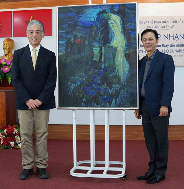Ông Naruse Tadahiro (trái), con trai họa sĩ  Naruse Tadayuki, chụp ảnh lưu niệm bên bức tranh cùng ông Trần Thanh Bình, Giám đốc Bảo tàng Mỹ thuật TP.HCM