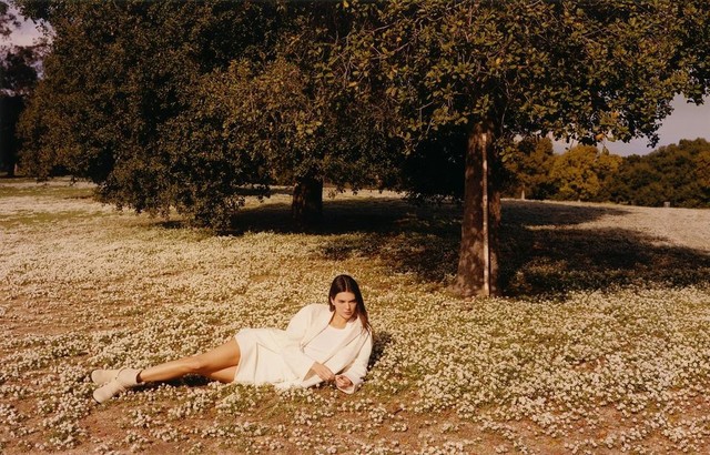 Kendall Jenner khoe dáng quyến rũ khi thả mình trên bãi cỏ với trang phục màu trắng gồm váy ngắn và áo khoác blazer