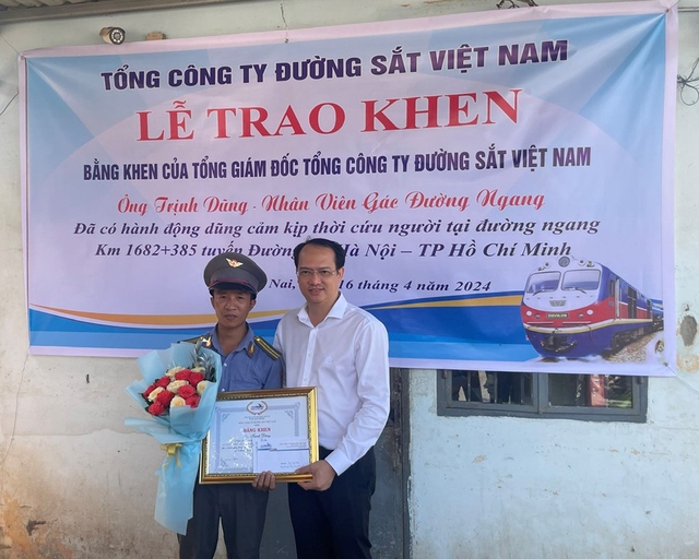 Ông Trần Anh Tuấn, Phó tổng giám đốc Tổng công ty Đường sắt VN, trao bằng khen cho anh Trịnh Dũng