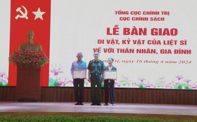 Đại tá Dương Văn Bảo, Phó trưởng phòng thương binh Liệt sĩ, người có công, Cục Chính sách Tổng cục Chính trị Quân đội nhân dân Việt Nam (giữa) bàn giao di vật, kỷ vật của liệt sĩ về với thân nhân, gia đình liệt sĩ