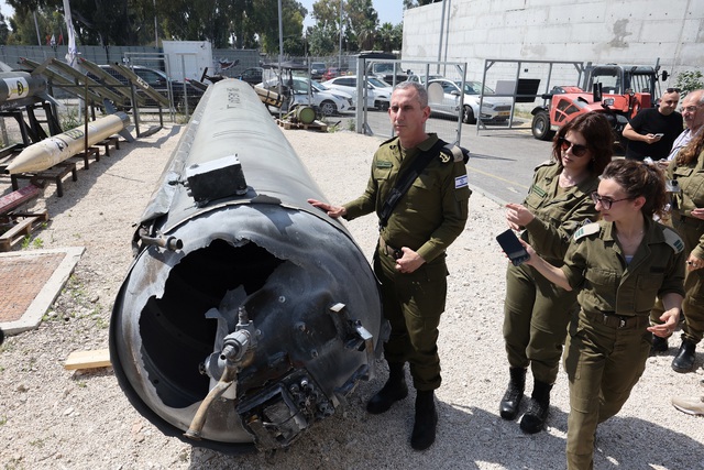 Phát ngôn viên quân đội Israel Daniel Hagari (giữa) cùng các thành viên khác của quân đội Israel đứng cạnh một tên lửa đạn đạo của Iran rơi ở Israel vào cuối tuần trước, tại căn cứ quân sự Julis gần thành phố Kiryat Malachi thuộc phía nam Israel ngày 16.4