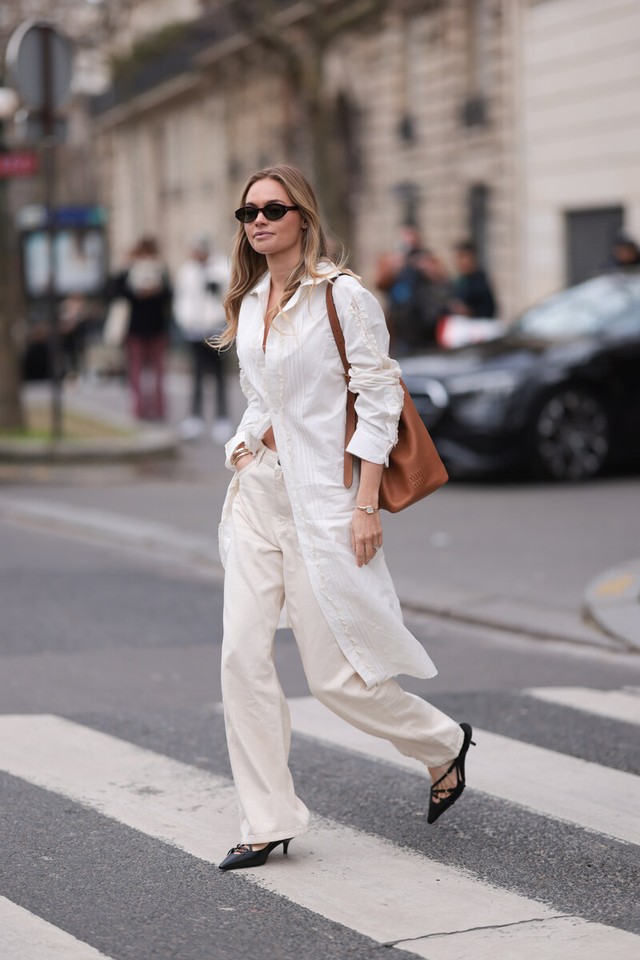 Trắng trên nền trắng, chọn kiểu dáng dài để mặc gợi cảm kết hợp với quần jeans có dây đeo chéo và túi đeo vai