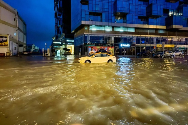 Taxi đi qua tuyến đường bị ngập tại Dubai