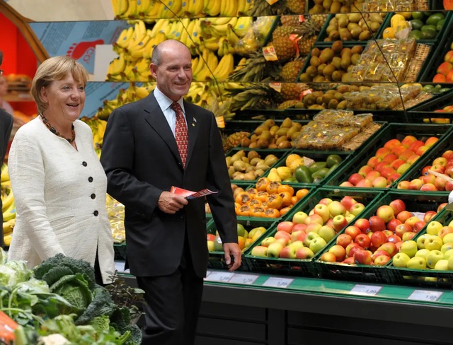 Tỉ phú Karl-Erivan Haub (phải) đi cùng cựu Thủ tướng Đức Angela Merkel năm 2009