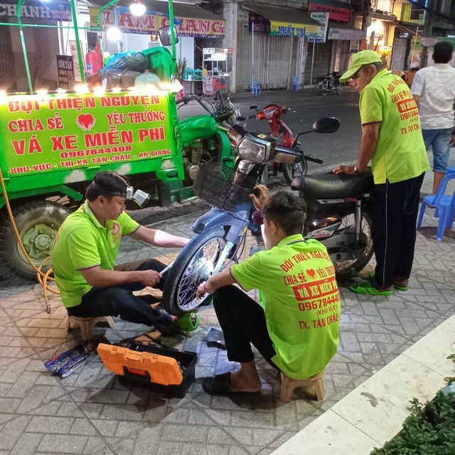 Ông Nguyễn Thanh Vân (trái) cùng các thành viên trong đội vá xe giúp người gặp sự cố về đêm