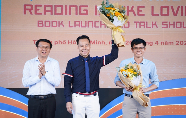 Ông Lâm Đình Thắng (trái) thay mặt Sở TT-TT TP.HCM và Phó tổng biên tập NXB Tổng hợp TP.HCM Trần Đình Ba tặng hoa chúc mừng tác giả