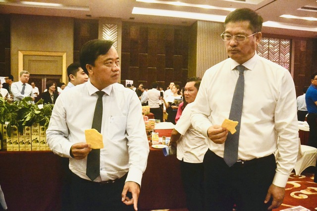 Chủ tịch UBND tỉnh Cà Mau Huỳnh Quốc Việt và Tổng lãnh sự Trung Quốc tại TP.HCM Ngụy Hoa Tường thưởng thức bánh phồng tôm của một doanh nghiệp Cà Mau