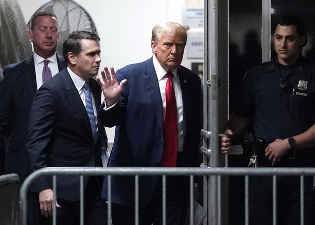 Ông Trump vẫy tay lúc bước vào phòng xét xử ngày 23.4