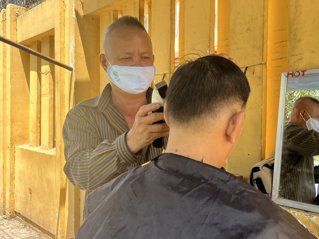 Ông Nguyễn Văn Tùng đang cắt tóc cho một vị khách quen