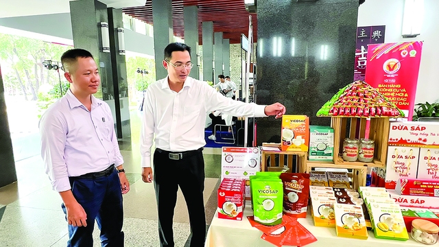 Anh Trần Duy Linh (phải) với sản phẩm từ dừa sáp