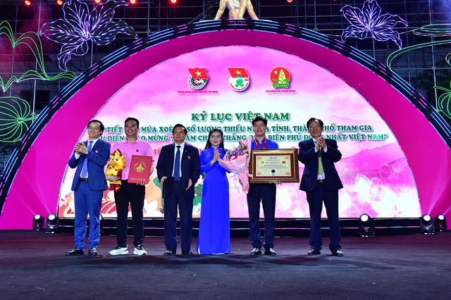 Chị Nguyễn Phạm Duy Trang tặng hoa cho Thường trực Hội đồng Đội T.Ư sau khi đón nhận kỷ lục Việt Nam với tiết mục múa xòe Tây Bắc