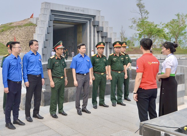 Đoàn đại biểu nghe hướng dẫn viên thuyết minh về ý nghĩa các biểu tượng, công trình kiến trúc của Đền thờ các liệt sĩ chiến trường Điện Biên Phủ