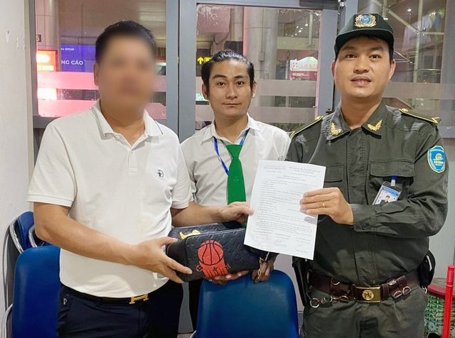 Lực lượng an ninh hàng không và ông Nguyễn Đăng Luyến (nhân viên điều hành taxi Mai Linh - giữa) trả lại túi xách có 318 triệu đồng cho ông L.D.T