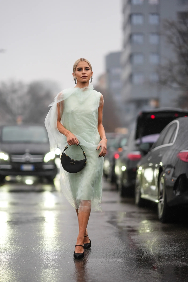 Caroline Daur mặc một chiếc váy không tay bằng vải tuyn màu xanh nhạt, túi da màu đen, giày múa ba lê trong Tuần lễ thời trang Milan thu đông 2024 - 2025