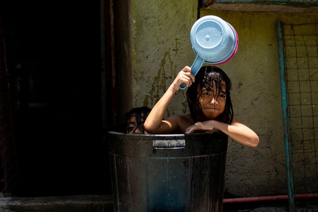 Trẻ em tắm trong ngày nắng nóng ở Manila (Philippines) ngày 25.4