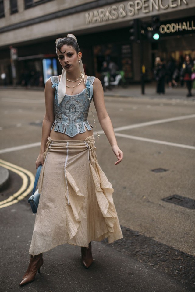 A nude dress will look great with both a sky-colored corset and a light blue clutch bag