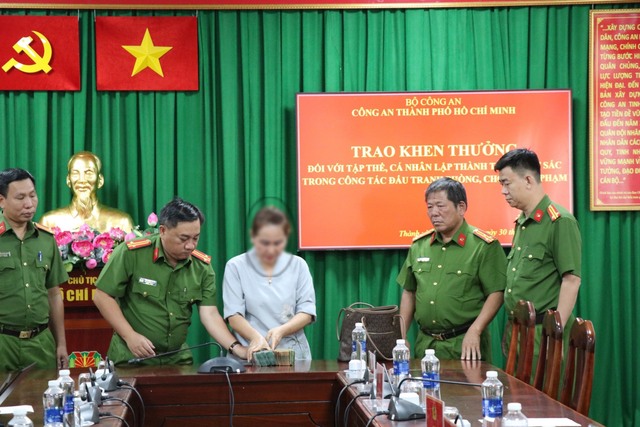 Công an trao trả 1,1 tỉ đồng cho nạn nhân (áo trắng)