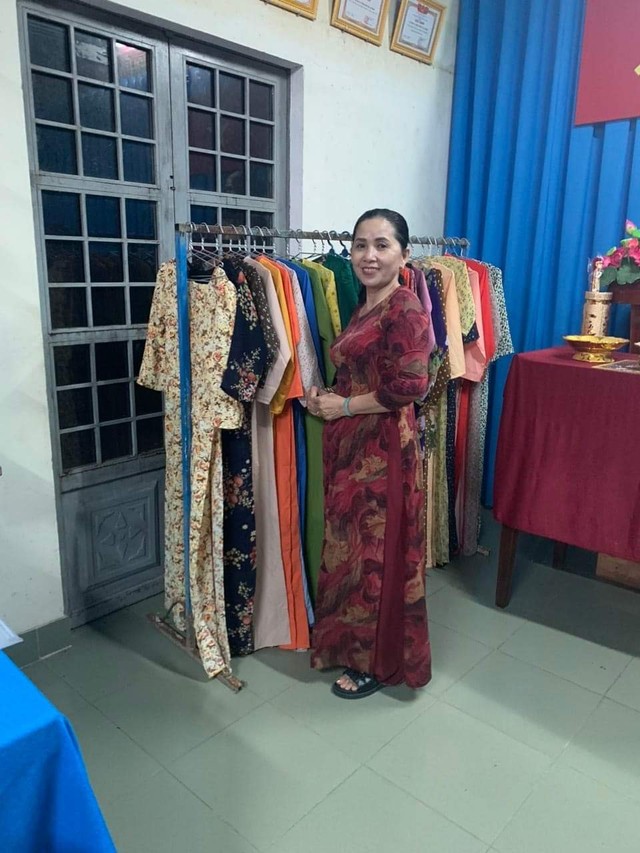 Cô giáo Lê Thị Hồng Việt bên sản phẩm áo dài quyên góp