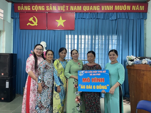Cô Lê Thị Hồng Việt (thứ 4, từ trái sang) trao áo dài cho phụ nữ ấp Phú Bình, xã An Phú, H.Củ Chi