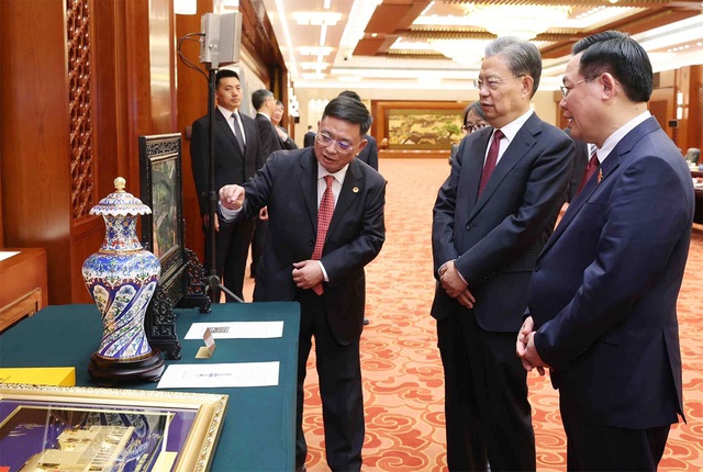 Chủ tịch Quốc hội Vương Đình Huệ và Ủy viên trưởng Ủy ban Thường vụ Nhân đại toàn quốc Trung Quốc Triệu Lạc Tế trao đổi tặng phẩm lưu niệm