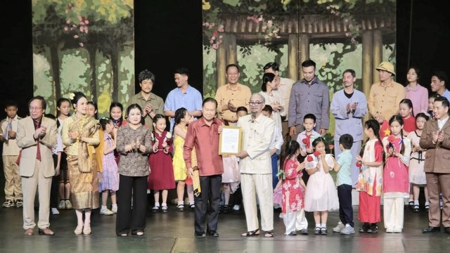 Ngài Chaleun Yiapaohe, Phó Chủ tịch Quốc hội Lào trân trọng trao hoa và tặng bằng khen cho nghệ sĩ ưu tú (NSƯT) Văn Hải - người đóng vai Bác Hồ trong vở kịch và sân khấu Lệ Ngọc