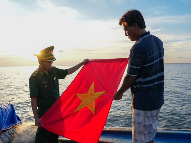 Trung úy quân nhân chuyên nghiệp Phạm Trung Chánh giúp ngư dân treo cờ Tổ quốc.