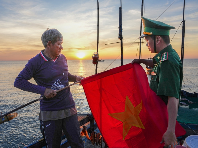Tặng và cùng ngư dân treo cờ Tổ quốc trên các phương tiện đánh bắt hải sản.