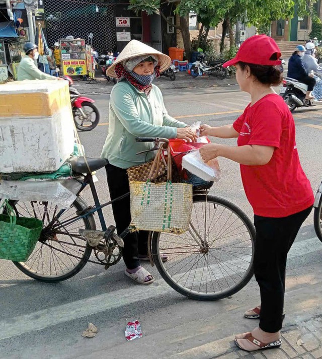 Thành viên bếp ăn từ thiện Trương Hải (phải), tặng suất ăn cho người lao động
