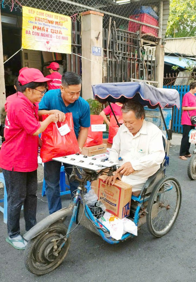 Một người bán vé số dạo được tặng phần cơm của bếp ăn từ thiện Trương Hải