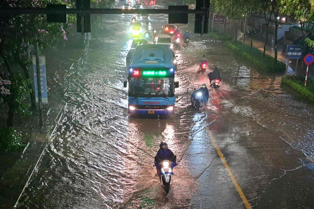 Dòng phương tiện đi vào giữa tim đường trên phố Hoàng Minh Giám để tránh vùng ngập nước