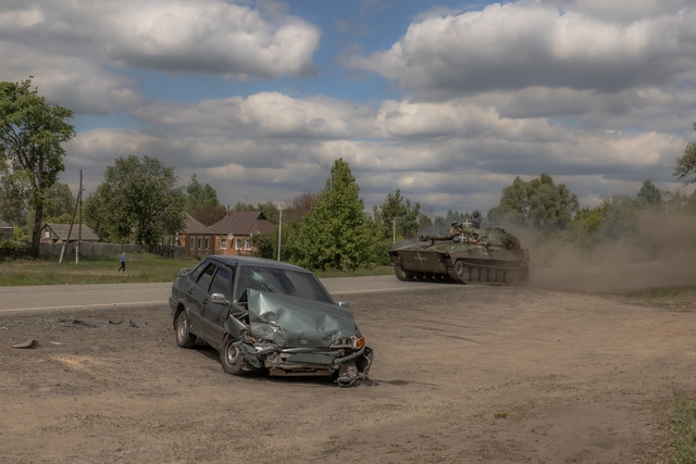 Pháo tự hành 2S1 Gvozdika của Ukraine di chuyển gần một chiếc xe hơi bị thiệt hại tại tỉnh Kharkiv hôm 12.5