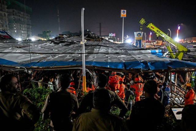Các thành viên Lực lượng Ứng phó Thiên tai Quốc gia tìm kiếm người sống sót ở hiện trường sụp đổ bảng quảng cáo ở trạm xăng Mumbai tối 13.5
