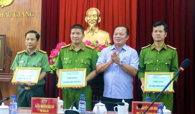 Ông Nguyễn Văn Hòa, Phó chủ tịch UBND tỉnh Hậu Giang, trao thưởng cho 3 tập thể đã xuất sắc giải cứu con tin bị bắt cóc
