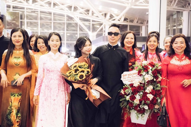 Đỗ Trịnh Hoài Nam diện áo dài đen kiểu truyền thống và ê kíp tại sân bay Nội Bài bắt đầu hành trình sang Mỹ tham dự Áo dài Festival lần thứ 6