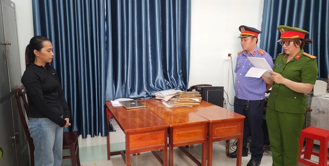 Bị can Nguyễn Thị Thu Trang (trái) nghe Công an tỉnh Kiên Giang đọc quyết định khởi tố, bắt tạm giam để điều tra về hành vi lừa đảo chiếm đoạt tài sản