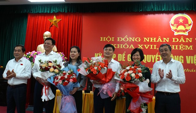 Ông Phạm Văn Nghiêm (thứ 4 từ trái qua) nhận hoa chúc mừng tại kỳ họp