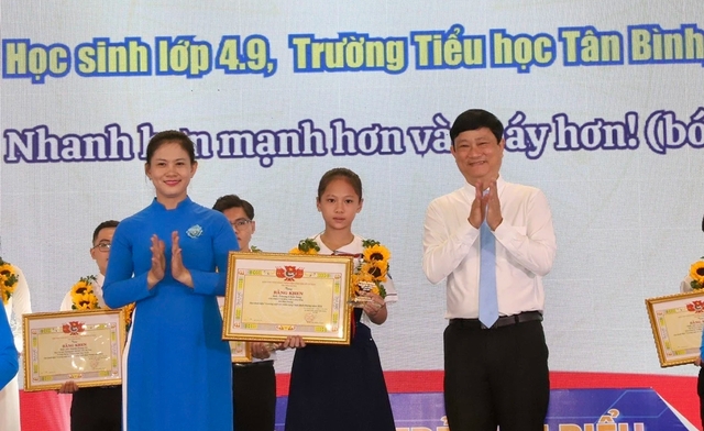 Ông Võ Văn Minh, Chủ tịch UBND tỉnh Bình Dương (bên phải) và chị Trần Thị Diễm Trinh, Bí thư Tỉnh đoàn tuyên dương gương Công dân trẻ tiêu biểu